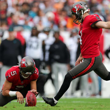 Dec 24, 2023; Tampa, Florida, USA;  Tampa Bay Buccaneers place kicker Chase McLaughlin (4) kicks a field goal held by punter Jake Camarda (5) against the Jacksonville Jaguars in the first quarter at Raymond James Stadium. Mandatory Credit: Nathan Ray Seebeck-USA TODAY Sports