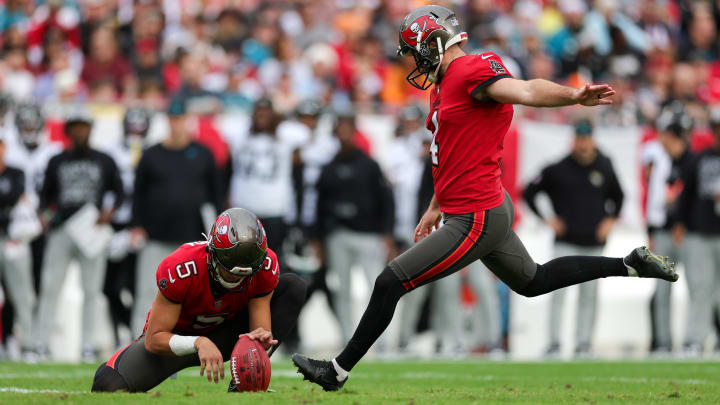 Dec 24, 2023; Tampa, Florida, USA;  Tampa Bay Buccaneers place kicker Chase McLaughlin (4) kicks a field goal held by punter Jake Camarda (5) against the Jacksonville Jaguars in the first quarter at Raymond James Stadium. Mandatory Credit: Nathan Ray Seebeck-USA TODAY Sports