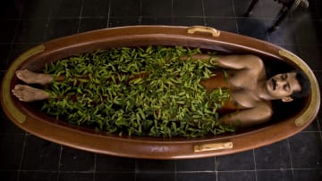 A patient lies in a herb infused tub of water