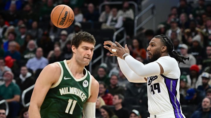 Sacramento Kings forward Jae Crowder passes the ball away from Milwaukee Bucks center Brook Lopez in the second quarter at Fiserv Forum on Tuesday.