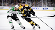 Oct 24, 2024; Boston, Massachusetts, USA;  Boston Bruins center Trent Frederic (11) controls the puck while Dallas Stars defenseman Mathew Dumba (3) defends during the first period at TD Garden. Mandatory Credit: Bob DeChiara-Imagn Images