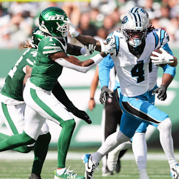 Oct 19, 2025; East Rutherford, New Jersey, USA; Carolina Panthers wide receiver Tetairoa McMillan (4) stiff arms New York Jets cornerback Sauce Gardner (1) in the second quarter at MetLife Stadium. Mandatory Credit: Vincent Carchietta-Imagn Images