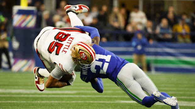 Seattle Seahawks cornerback Devon Witherspoon (21) tackles San Francisco 49ers tight end George Kittle (85)