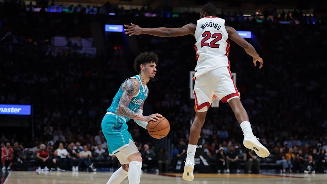 Oct 28, 2025; Miami, Florida, USA; Charlotte Hornets guard LaMelo Ball (1) fakes a shot against Miami Heat forward Andrew Wiggins (22) during the second quarter at Kaseya Center. Mandatory Credit: Sam Navarro-Imagn Images