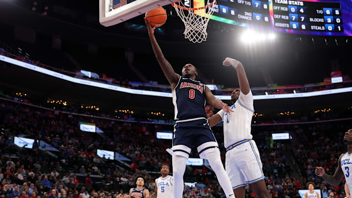 Nov 14, 2025; Inglewood, California, USA;  Arizona Wildcats guard Jaden Bradley (0) goes to the basket against UCLA Bruins center Xavier Booker (1) during the first half of the Hall of Fame Series game at Intuit Dome. Mandatory Credit: Kiyoshi Mio-Imagn Images