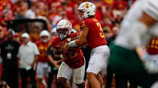 Iowa State Cyclones quarterback Rocco Becht hands the ball off during a college football game in the Big 12.
