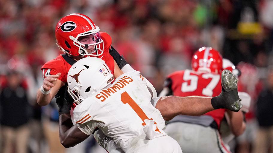 Texas edge Colin Simmons tackles Georgia quarterback Gunner Stockton last season.