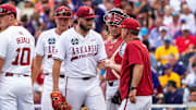 Arkansas Razorbacks starting pitcher Zach Root hands the ball to Hogs coach Dave Van Horn after being pulled in the second inning of Saturday night's 4-1 loss to the LSU Tigers at Charles Schwab Field in Omaha, Neb.