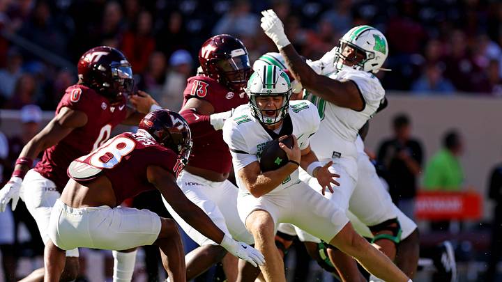 Sep 7, 2024; Blacksburg, Virginia, USA; Marshall Thundering Herd quarterback Stone Earle (11) runs the ball against Virginia Tech Hokies safety Mose Phillips III (18) during the first quarter at Lane Stadium. Mandatory Credit: Peter Casey-Imagn Images