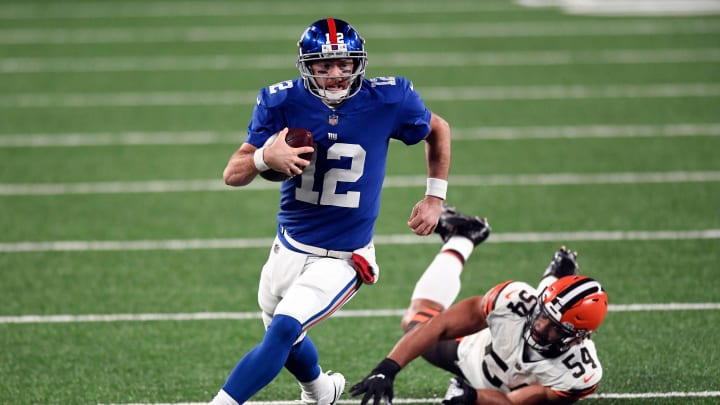 New York Giants quarterback Colt McCoy (12) breaks a tackle by Cleveland Browns defensive end Olivier Vernon (54) during a game at MetLife Stadium on Sunday, December 20, 2020, in East Rutherford. 