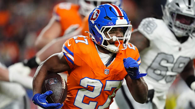 Broncos running back J.K. Dobbins carries the football.