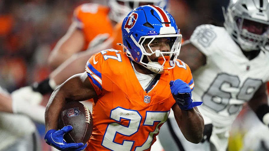 Broncos running back J.K. Dobbins carries the football.