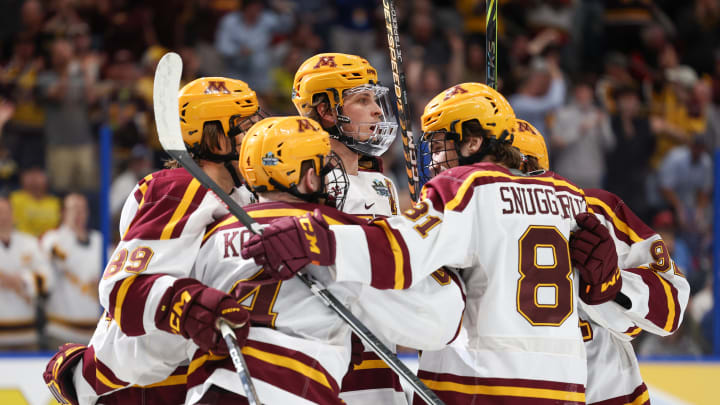 Apr 6, 2023; Tampa, Florida, USA; Minnesota defenseman Mike Koster (4) is congratulated by forward Minnesota forward Jimmy Snuggerud (81) after scoring a goal against Boston University in the first period in the semifinals of the 2023 Frozen Four college ice hockey tournament at Amalie Arena. Mandatory Credit: Nathan Ray Seebeck-USA TODAY Sports