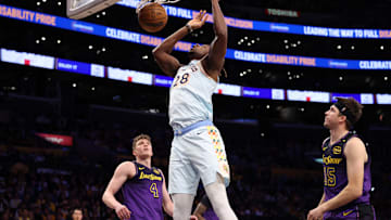 Jan 13, 2025; Los Angeles, California, USA;  San Antonio Spurs center Charles Bassey (28) dunks a ball against Los Angeles Lakers guard Dalton Knecht (4) and guard Austin Reaves (15) during the second half at Crypto.com Arena. Mandatory Credit: Kiyoshi Mio-Imagn Images
