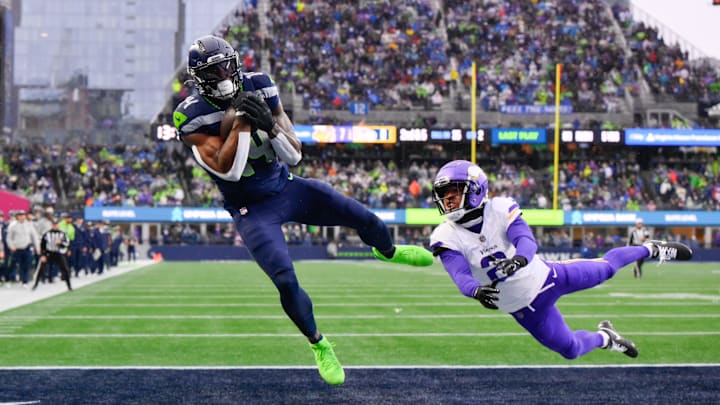 Dec 22, 2024; Seattle, Washington, USA; Seattle Seahawks wide receiver DK Metcalf (14) catches a pass for a touchdown while defended by Minnesota Vikings cornerback Stephon Gilmore (2) during the first half at Lumen Field.
