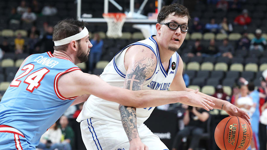 Saint Louis Billikens center Robbie Avila handles the ball against Dayton Flyers forward Jacob Conner.
