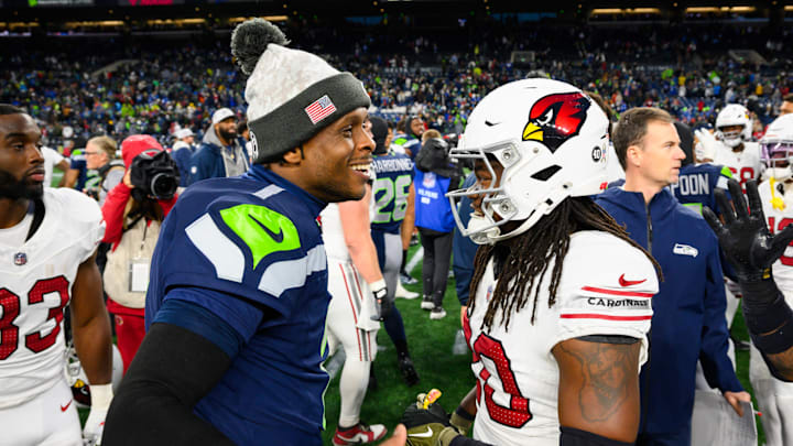 Nov 24, 2024; Seattle, Washington, USA; Seattle Seahawks quarterback Geno Smith (7) and Arizona Cardinals running back DeeJay Dallas (20) greet each other after the game at Lumen Field. Mandatory Credit: Steven Bisig-Imagn Images