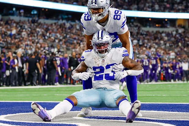 Dallas Cowboys running back Rico Dowdle is helped up by tight end Brevyn Spann-Ford