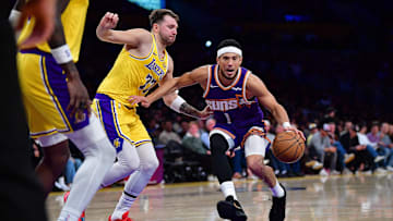 Phoenix Suns guard Devin Booker (1) moves to the basket against Los Angeles Lakers guard Luka Doncic (77) during the first half at Crypto.com Arena. Mandatory Credit: Gary A. Vasquez-Imagn Images