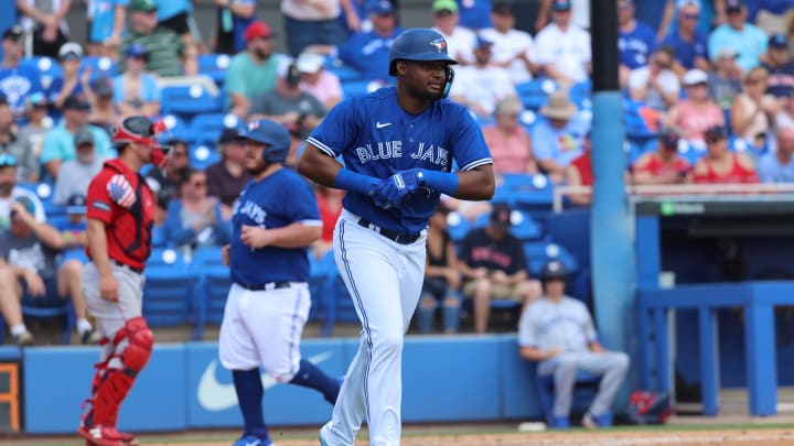 Mar 13, 2023; Dunedin, Florida, USA; Toronto Blue Jays infielder Orelvis Martinez (2) walks as catcher Alejandro Kirk (30) scores a run as bases are loaded against the Boston Red Sox during the third inning  at TD Ballpark.