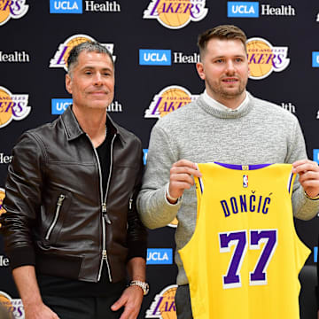 Los Angeles Lakers guard Luka Doncic poses for photos with general manager Rob Pelinka and head coach JJ Redick.