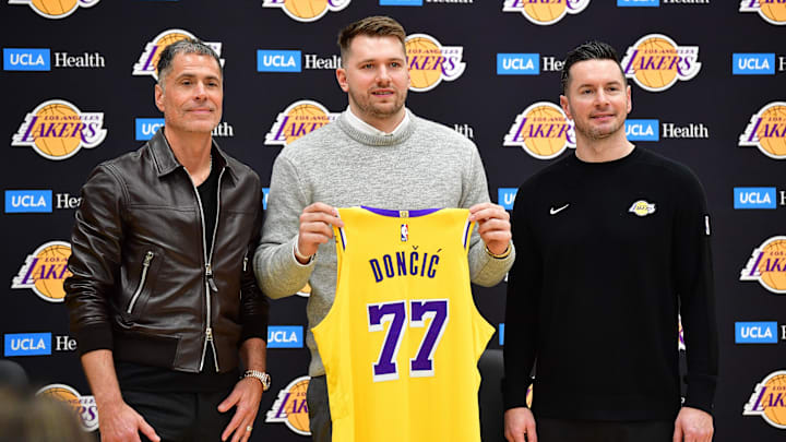 Los Angeles Lakers guard Luka Doncic poses for photos with general manager Rob Pelinka and head coach JJ Redick 