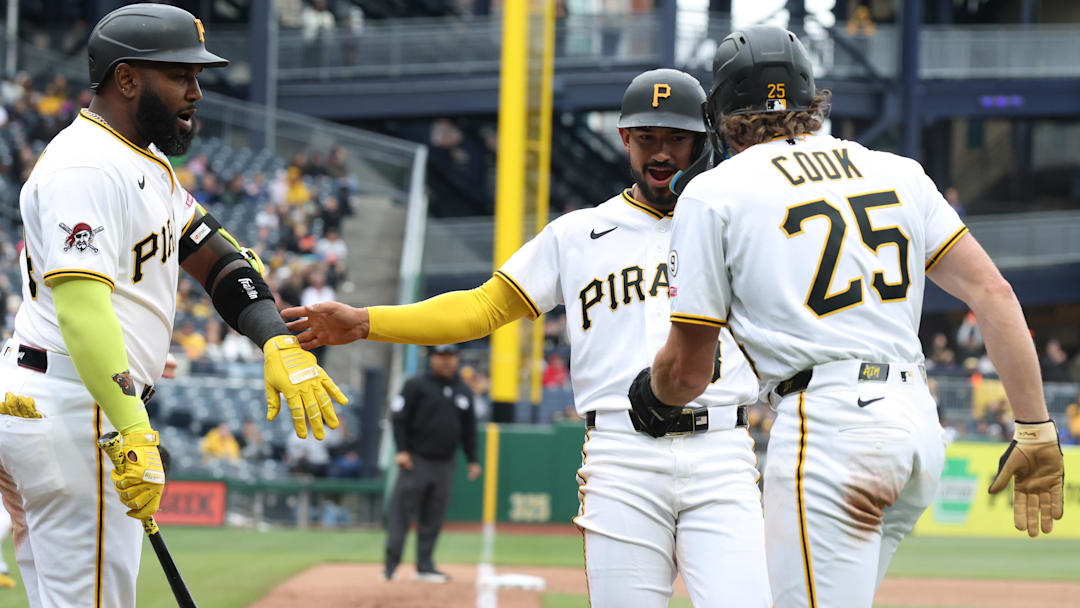 Pittsburgh Pirates designated hitter Marcell Ozuna (left) and first baseman Billy Cook (25) greet second baseman Nick Gonzales.