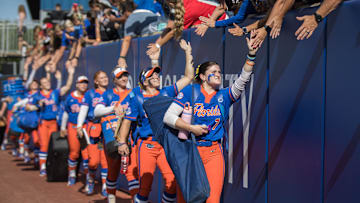 May 30, 2025; Oklahoma City, OK, USA;  Florida Gators pitcher Keagan Rothrock (7) and her teammates greet fans as they enter the stadium to play the Tennessee Lady Volunteers in the NCAA Softball Women's College World Series at Devon Park. Mandatory Credit: Brett Rojo-Imagn Images