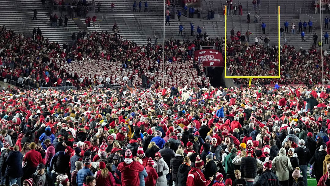 Wisconsin Badgers fans storm the field after a 27-10 win over the Illinois Fighting Illini at Camp Randall Stadium.