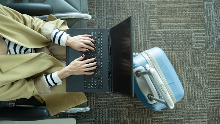 A traveler works on her laptop during a layover