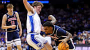 Mar 27, 2025; Newark, NJ, USA; Arizona Wildcats guard KJ Lewis (5) drives to the basket against Duke Blue Devils guard Kon Knueppel (7) during the second half during an East Regional semifinal of the 2025 NCAA tournament at Prudential Center. Mandatory Credit: Vincent Carchietta-Imagn Images