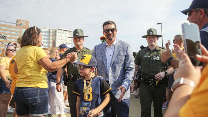 Aug 31, 2024; Morgantown, West Virginia, USA; West Virginia Mountaineers head coach Neal Brown greets fans during the Man Trip as the team arrives before their game against the Penn State Nittany Lions at Mountaineer Field at Milan Puskar Stadium. Mandatory Credit: Ben Queen-Imagn Images