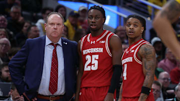 Mar 16, 2025; Indianapolis, IN, USA; Wisconsin Badgers head coach Greg Gard, guard John Blackwell (25) and guard Kamari McGee (4) talk during a pause in play during the second half against the Michigan Wolverines during the 2025 Big Ten Championship Game at Gainbridge Fieldhouse. 