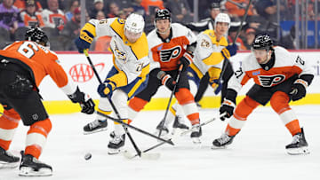 Mar 31, 2025; Philadelphia, Pennsylvania, USA; Nashville Predators left wing Kieffer Bellows (26) reaches for the puck against Philadelphia Flyers left wing Noah Cates (27) in the first period at Wells Fargo Center. 
