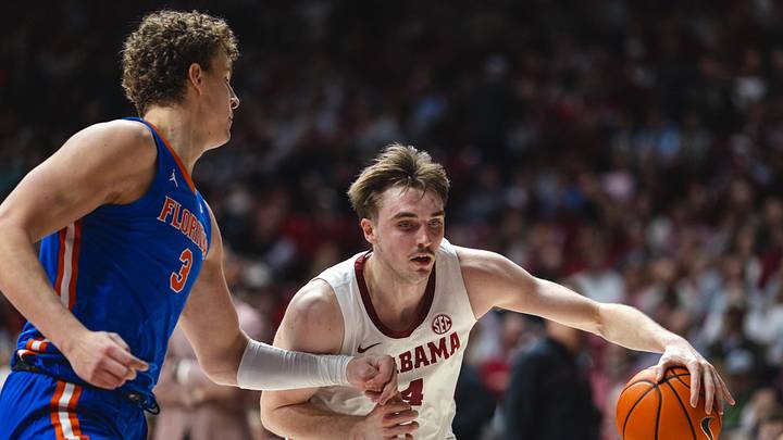 Mar 5, 2025; Tuscaloosa, Alabama, USA; Alabama Crimson Tide forward Grant Nelson (4) drives the ball against Florida Gators center Micah Handlogten (3) during the second half at Coleman Coliseum. Mandatory Credit: Will McLelland-Imagn Images