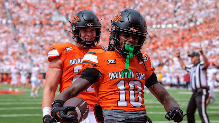 Sep 7, 2024; Stillwater, Oklahoma, USA; Oklahoma State Cowboys cornerback Kale Smith (10) celebrates in the end zone after a touchdown during the second quarter against the Arkansas Razorbacks at Boone Pickens Stadium. Mandatory Credit: William Purnell-Imagn Images