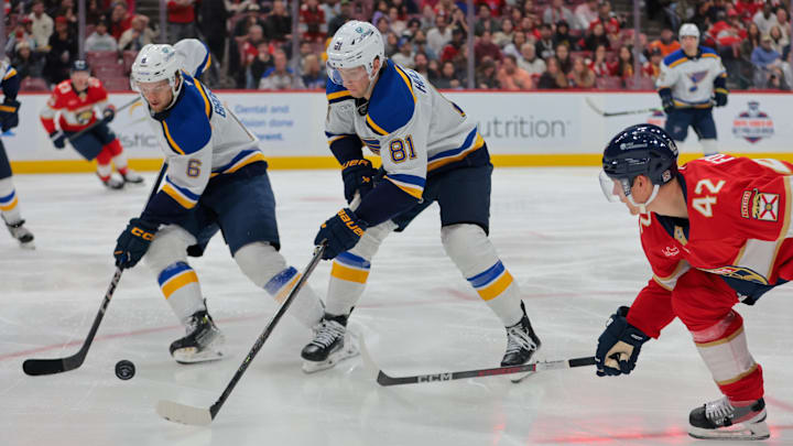 Dec 20, 2024; Sunrise, Florida, USA; St. Louis Blues center Dylan Holloway (81) moves the puck past Florida Panthers defenseman Gustav Forsling (42) during the second period at Amerant Bank Arena. Mandatory Credit: Sam Navarro-Imagn Images