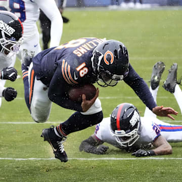 Nov 9, 2025; Chicago, Illinois, USA; Chicago Bears quarterback Caleb Williams (18) runs against New York Giants cornerback Dru Phillips (22), linebacker Bobby Okereke (58) and cornerback Cor'Dale Flott (28) during the second half at Soldier Field. Mandatory Credit: David Banks-Imagn Images