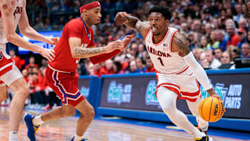 Mar 8, 2025; Lawrence, Kansas, USA; Arizona Wildcats guard Caleb Love (1) drives to the basket around Kansas Jayhawks guard Dajuan Harris Jr. (3) during the first half at Allen Fieldhouse. Mandatory Credit: William Purnell-Imagn Images