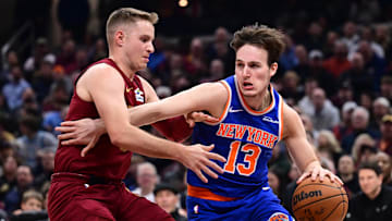 Apr 2, 2025; Cleveland, Ohio, USA;  New York Knicks guard Tyler Kolek (13) drives to the basket against Cleveland Cavaliers guard Sam Merrill (5) during the first half at Rocket Arena. Mandatory Credit: Ken Blaze-Imagn Images