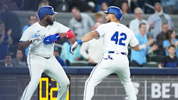 Apr 15, 2025; Toronto, Ontario, CAN; Toronto Blue Jays designated hitter Anthony Santander (25) hits a three run home run and celebrates with first baseman Vladimir Guerrero Jr. (27) against the Atlanta Braves during the fifth inning at Rogers Centre. All players wore #42 for Jackie Robinson Day. Mandatory Credit: Nick Turchiaro-Imagn Images