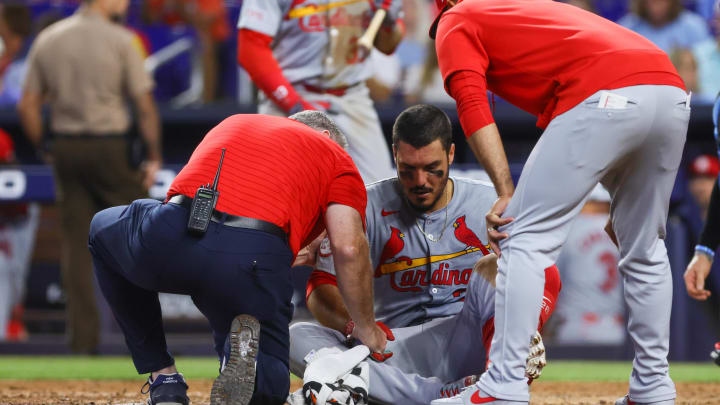 Jun 19, 2024; Miami, Florida, USA; St. Louis Cardinals third baseman Nolan Arenado (28) gets looked at by a trainer and manager Oliver Marmol (37) after getting hit by a pitch during the eighth inning against the Miami Marlins at loanDepot Park. Mandatory Credit: Sam Navarro-USA TODAY Sports
