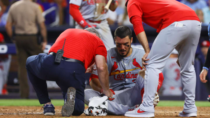 Jun 19, 2024; Miami, Florida, USA; St. Louis Cardinals third baseman Nolan Arenado (28) gets looked at by a trainer and manager Oliver Marmol (37) after getting hit by a pitch during the eighth inning against the Miami Marlins at loanDepot Park.