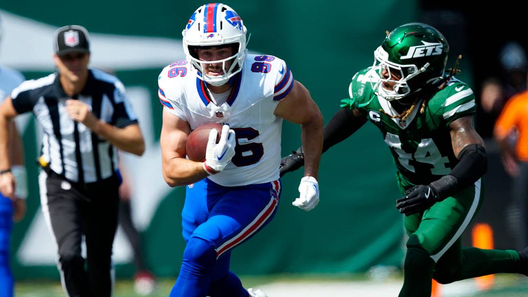 Buffalo Bills tight end Dalton Kincaid (86) runs with the ball as New York Jets linebacker Jamien Sherwood (44) runs towards him in hopes of a tackle.