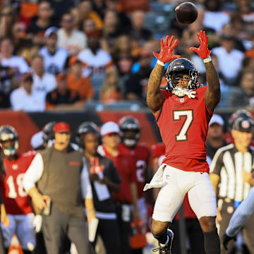 Aug 10, 2024; Cincinnati, Ohio, USA; Tampa Bay Buccaneers running back Bucky Irving (7) catches a pass against Cincinnati Bengals safety Vonn Bell (24) in the first half at Paycor Stadium. Mandatory Credit: Katie Stratman-Imagn Images