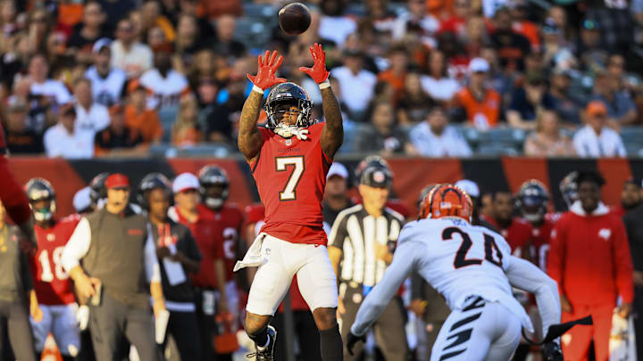 Aug 10, 2024; Cincinnati, Ohio, USA; Tampa Bay Buccaneers running back Bucky Irving (7) catches a pass against Cincinnati Bengals safety Vonn Bell (24) in the first half at Paycor Stadium. Mandatory Credit: Katie Stratman-Imagn Images