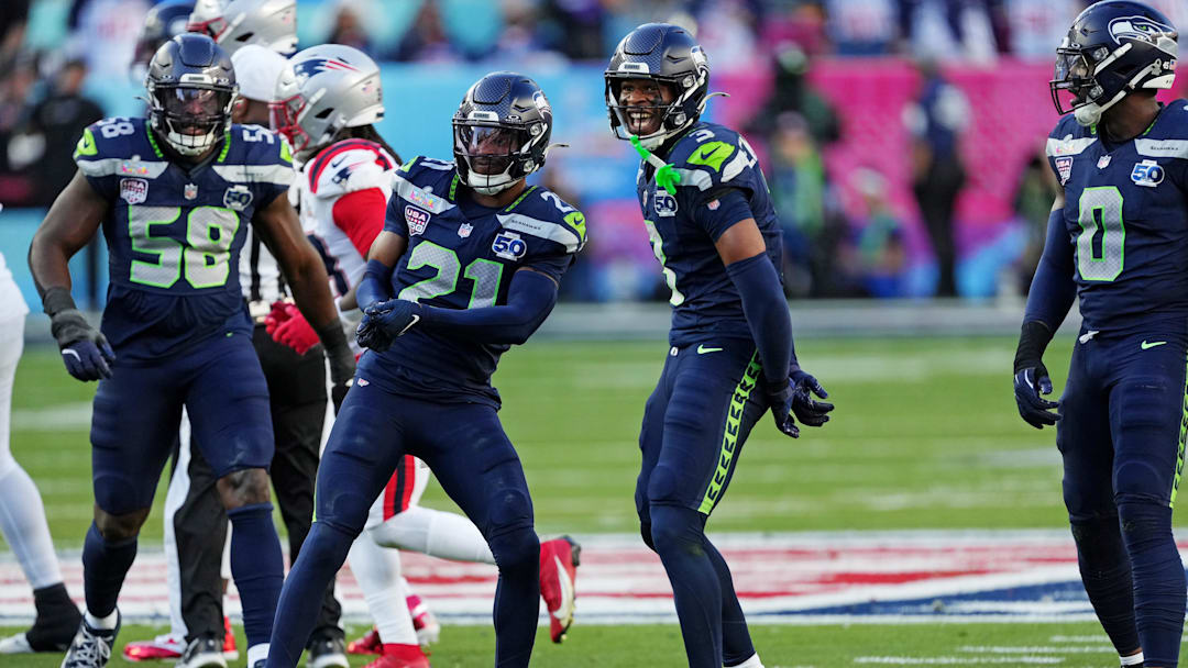 Seattle Seahawks defensive end DeMarcus Lawrence (0) and Seattle Seahawks cornerback Devon Witherspoon (21) react after a play.