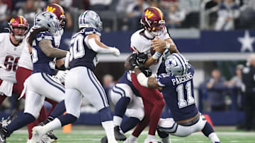 Jan 5, 2025; Arlington, Texas, USA; Washington Commanders quarterback Jayden Daniels (5) is gang tackled by the Dallas Cowboys defense during the second quarter at AT&T Stadium. Mandatory Credit: Tim Heitman-Imagn Images