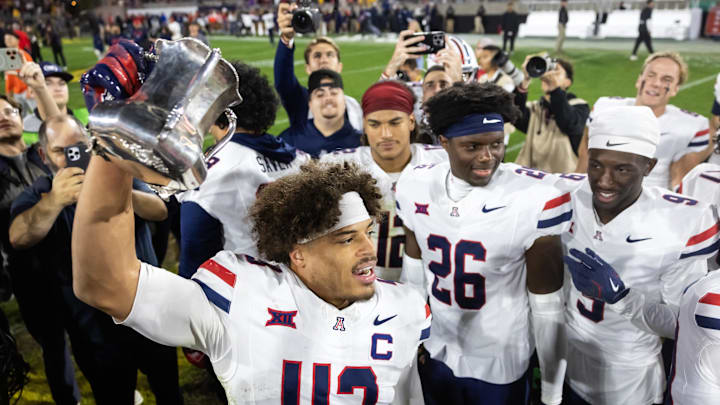 Nov 28, 2025; Tempe, Arizona, USA; Arizona Wildcats defensive back Dalton Johnson (43) celebrates with the Territorial Cup trophy after defeating the Arizona State Sun Devils in the 99th Territorial Cup at Mountain America Stadium. Mandatory Credit: Mark J. Rebilas-Imagn Images