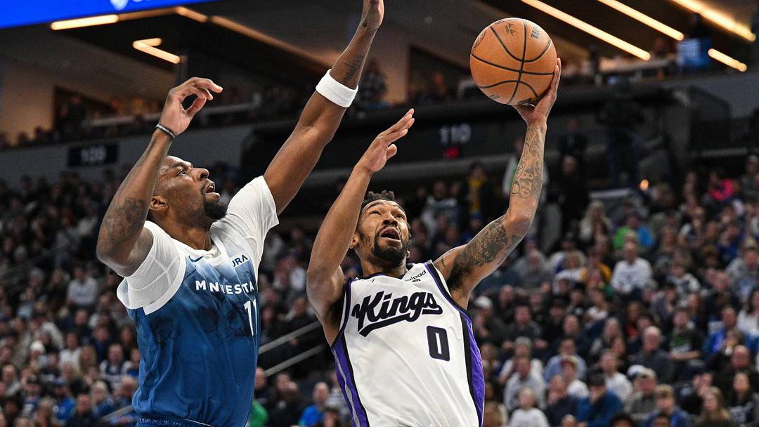 Nov 24, 2023; Minneapolis, Minnesota, USA; Sacramento Kings guard Malik Monk (0) goes to the basket while contested by Minnesota Timberwolves forward Naz Reid (11).